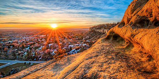 Fine art landscape photograph of a red starbust sunset over the rimrocks in Billings, MT.